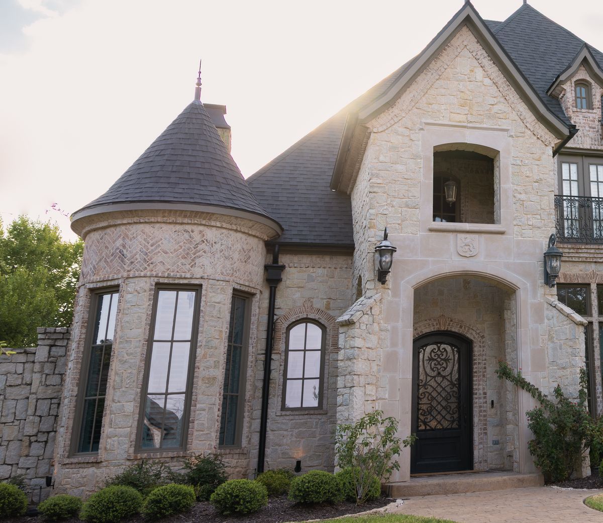 Stone estate with a turret and steep slate-look roof